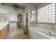 Bathroom boasts soaking tub and a glass block window for natural light and privacy at 22204 N 55Th St, Phoenix, AZ 85054