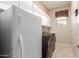 Bright laundry room features modern washer and dryer units, ample storage cabinets, and tiled flooring at 22204 N 55Th St, Phoenix, AZ 85054