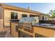 Outdoor kitchen area featuring a built-in grill with granite countertops and stone accents at 22204 N 55Th St, Phoenix, AZ 85054
