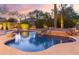 Sparkling backyard pool with a rock waterfall feature and lush desert landscaping at 22204 N 55Th St, Phoenix, AZ 85054