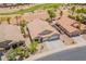 Aerial view of a home showing a three car garage and landscaping, with a desert golf course in the background at 22625 N Van Loo Dr, Maricopa, AZ 85138