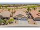 This is an aerial view of a beautiful home showing a three car garage, desert landscaping, and a golf course nearby at 22625 N Van Loo Dr, Maricopa, AZ 85138