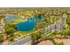 Aerial view of a community featuring lush green golf course, blue lake, palm trees and well-maintained streets at 22625 N Van Loo Dr, Maricopa, AZ 85138