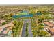 Overhead shot of neighborhood offering green spaces, lake, golf course, palm tree-lined streets, and residential homes at 22625 N Van Loo Dr, Maricopa, AZ 85138