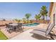 Inviting backyard with a pool, lounge chairs, a dining set, and landscaping for outdoor enjoyment at 22625 N Van Loo Dr, Maricopa, AZ 85138