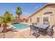 Relaxing backyard featuring a refreshing pool, palm trees, and outdoor dining area, perfect for enjoying sunny days at 22625 N Van Loo Dr, Maricopa, AZ 85138