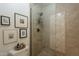 Elegant bathroom featuring a glass shower door with tile walls, a sleek shower head, and decorative artwork at 22625 N Van Loo Dr, Maricopa, AZ 85138