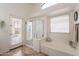 Bright bathroom featuring a tub and separate shower with a door leading to the exterior at 22625 N Van Loo Dr, Maricopa, AZ 85138