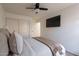 This cozy bedroom has a ceiling fan, a wall-mounted television, and plenty of closet space at 22625 N Van Loo Dr, Maricopa, AZ 85138