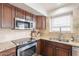 Kitchen featuring updated stainless steel appliances and granite counters at 22625 N Van Loo Dr, Maricopa, AZ 85138