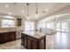 Open kitchen with granite island, stainless appliances, and views to the living room at 22625 N Van Loo Dr, Maricopa, AZ 85138