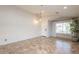 Bright living room with tile floors, wainscoting, and a view of the front yard at 22625 N Van Loo Dr, Maricopa, AZ 85138