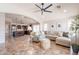 Open-concept living room with tile floors, comfortable seating, and seamless access to the kitchen at 22625 N Van Loo Dr, Maricopa, AZ 85138