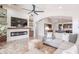 Modern living room featuring a sleek fireplace, built-in shelving, and open access to the kitchen at 22625 N Van Loo Dr, Maricopa, AZ 85138