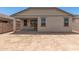 A spacious backyard features neutral stucco walls, trimmed windows and sliding glass doors to the home's interior at 22913 N 183Rd Dr, Surprise, AZ 85387