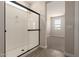 Modern bathroom with glass-enclosed shower stall and tiled floors; a doorway leads to the bedroom at 22913 N 183Rd Dr, Surprise, AZ 85387