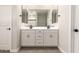 Bathroom featuring double sink vanity with white cabinets, sleek black hardware, and large mirror at 22913 N 183Rd Dr, Surprise, AZ 85387