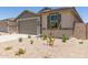A single-story home featuring a two-car garage, neutral color palette, and desert landscaping at 22913 N 183Rd Dr, Surprise, AZ 85387