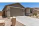 A single-story home featuring a two-car garage, neutral color palette, and desert landscaping at 22913 N 183Rd Dr, Surprise, AZ 85387