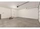 A clean garage with smooth concrete floor, offering versatile space for parking and projects at 22913 N 183Rd Dr, Surprise, AZ 85387