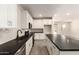 Modern kitchen features white cabinets, subway tile backsplash, stainless steel appliances, and an island with black countertops at 22913 N 183Rd Dr, Surprise, AZ 85387