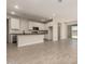 Open kitchen layout with island, white cabinets, stainless steel appliances, and tile floors at 22913 N 183Rd Dr, Surprise, AZ 85387