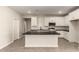 Open kitchen layout with island, white cabinets, stainless steel appliances, and tile floors at 22913 N 183Rd Dr, Surprise, AZ 85387