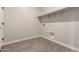 A well-lit laundry room features tile flooring, utility connections, and shelving for efficient organization at 22913 N 183Rd Dr, Surprise, AZ 85387
