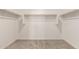 Bright walk-in closet features carpeted floor and wooden hanging rods at 22913 N 183Rd Dr, Surprise, AZ 85387
