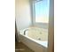 Relaxing bathtub with garden window to let in the sun while you unwind at 23284 W Pima St, Buckeye, AZ 85326