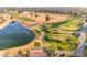 An aerial view shows a golf course with a pond and palm trees throughout the community at 23753 S Vacation Way, Sun Lakes, AZ 85248