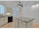 Well-lit kitchen with a tile floor, kitchen island and shuttered windows at 23753 S Vacation Way, Sun Lakes, AZ 85248
