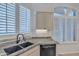 Well-lit kitchen featuring a black composite sink, granite countertops and shuttered windows at 23753 S Vacation Way, Sun Lakes, AZ 85248