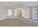 Bright, airy living room with high ceilings, plush carpet, and sliding glass doors at 23753 S Vacation Way, Sun Lakes, AZ 85248