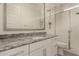 Modern bathroom with granite countertops, white cabinets, walk-in shower, and framed mirror at 24478 N 166Th Ave, Surprise, AZ 85387