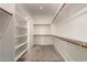 Walk-in closet featuring built in shelving and carpeted floors at 24478 N 166Th Ave, Surprise, AZ 85387