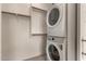 This laundry room features a stacked washer and dryer and built-in shelves for efficient space utilization at 24478 N 166Th Ave, Surprise, AZ 85387