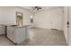 Open-concept kitchen and living area with sleek white cabinets and neutral tile flooring at 24478 N 166Th Ave, Surprise, AZ 85387