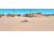 Exterior view of the home and sheds on a lot with desert landscape and sunny skies at 270 S Ralston Rd, Maricopa, AZ 85139