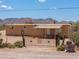 Tan single-story home with a metal gate and desert landscaping in a rural Arizona setting at 270 S Ralston Rd, Maricopa, AZ 85139