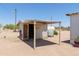 Outside shot of a shed with a weathered overhang, and a water tank in a desert-like surrounding at 270 S Ralston Rd, Maricopa, AZ 85139