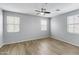 Spacious bedroom with three windows, ceiling fan, and modern wood-look flooring at 2941 E Darrow St, Phoenix, AZ 85042