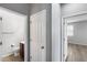 Hallway view showing a door to a half bath and a bedroom with neutral paint and wood-look tile flooring at 2941 E Darrow St, Phoenix, AZ 85042