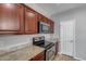 A modern kitchen featuring dark cabinets, granite countertops, and stainless steel appliances at 2941 E Darrow St, Phoenix, AZ 85042