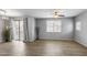 Bright living room with wood-look tile floors, neutral walls, and a sliding door to a balcony at 2941 E Darrow St, Phoenix, AZ 85042