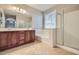 A bathroom with a double sink vanity, soaking tub, and glass shower at 29828 N 72Nd Ln, Peoria, AZ 85383
