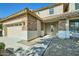 Home featuring a two-car garage, stone accents, a walkway to the front door and a well-manicured front yard at 29828 N 72Nd Ln, Peoria, AZ 85383