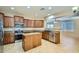 Kitchen featuring wood cabinets, granite countertops, stainless steel appliances, and a center island at 29828 N 72Nd Ln, Peoria, AZ 85383