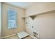 Functional laundry room with tiled flooring, built-in shelf, and window for natural light at 29828 N 72Nd Ln, Peoria, AZ 85383