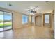 Spacious living room featuring tile floors, neutral walls, a ceiling fan, multiple windows, and a sliding glass door at 29828 N 72Nd Ln, Peoria, AZ 85383